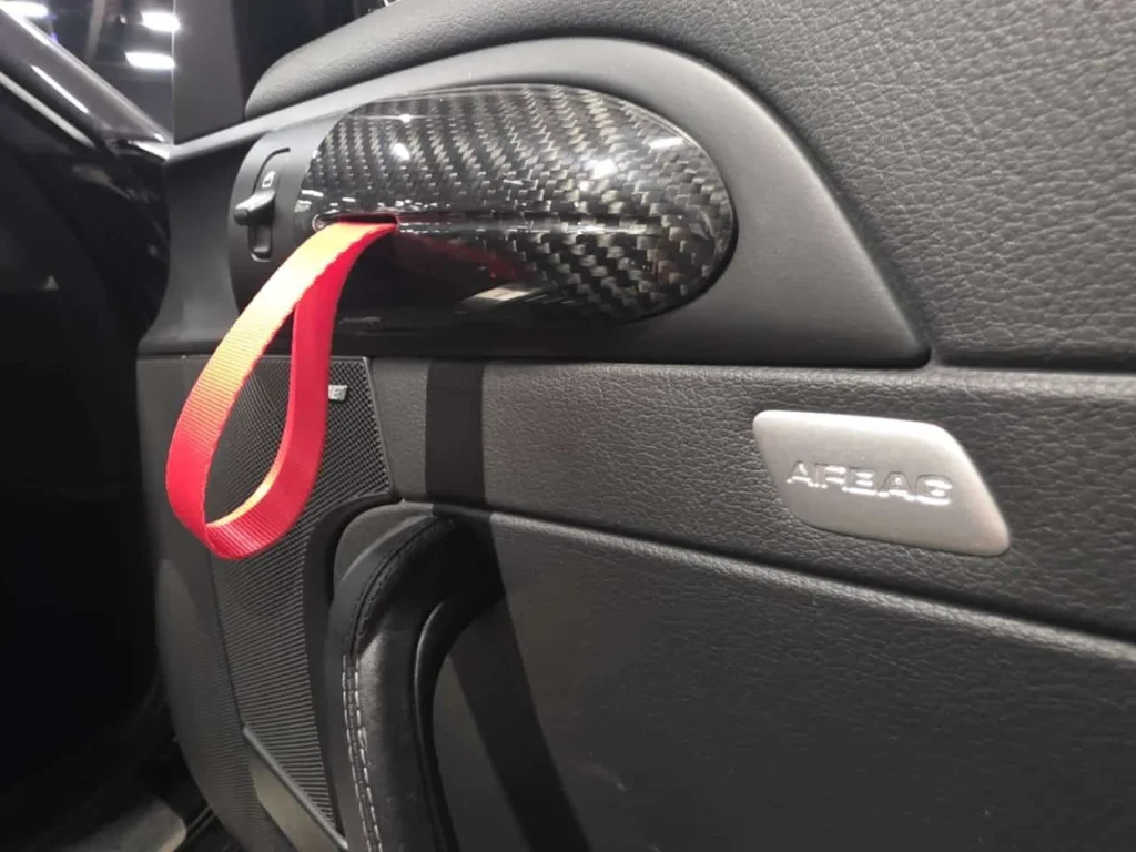 Rød strap ved dørhåndtaget i Porsche 997-kabinen.