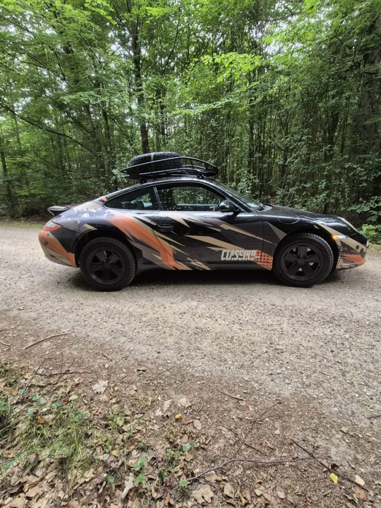 Porsche 997 Safari set fra siden på grusvej i skoven.